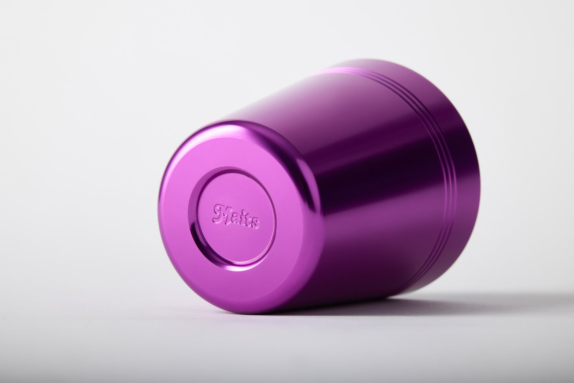 Purple anodised aluminium cup showing embossed Maits logo on base